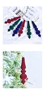 Close-up of velvet flocked tapered Christmas ornaments in red, green, and blue on a tree