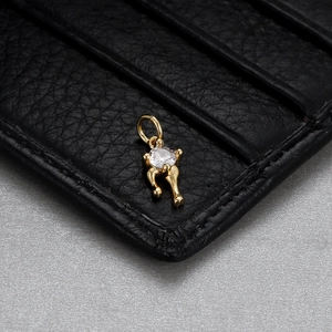 Detail of a golden pendant with transparent gemstone on black leather texture
