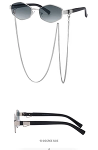 Detail view of silver hexagonal sunglasses with grey gradient lenses and metal chain