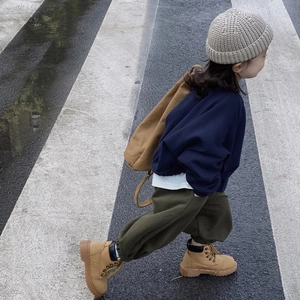 Detalle de un niño con un gorro de punto beige para actividades al aire libre en otoño e invierno