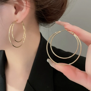 Close-up of elegant double-layered gold hoop earrings worn on model for a stylish look