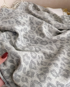 Close-up of soft leopard print cashmere-like scarf texture with elegant grey fringe details