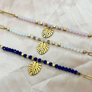 Handmade beaded bracelet set with 18k gold monstera leaf pendants on champagne satin