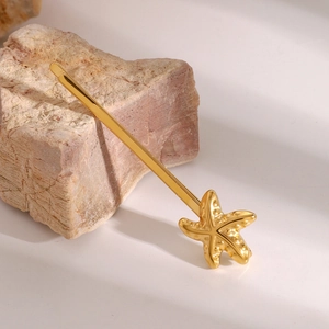 Makro-Detail der goldenen Seestern-Haarklammer mit strukturierter Metalloberfläche