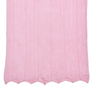 Détail du tissu en maille rose avec des côtes verticales et un ourlet festonné ondulé