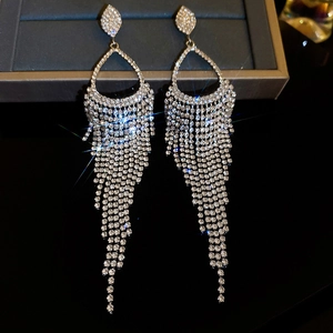 Close-up of elegant silver tassel earrings with sparkling rhinestones and pearls