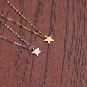 Polished stainless steel star pendant necklaces in gold and silver on wooden background