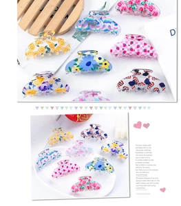 Detail view of assorted 8cm PVC claw clips with lemon, strawberry, and floral patterns