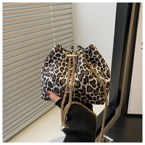 Detail of leopard print bucket bag with golden chain strap and pearl pendant accent