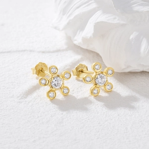 Macro shot of S925 engraved gold-plated floral earrings with white cubic zirconia stones