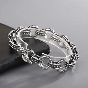 Close-up of vintage silver chain bracelet with embossed textured links and OT toggle clasp