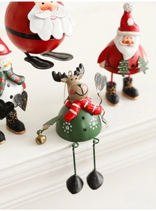 Close-up of painted metal reindeer ornament with festive red scarf and golden bell detail