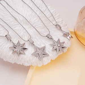 Elegant silver snake chain necklace featuring zircon-encrusted star pendants on coral decor