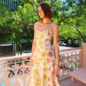 Floral print midi dress with spaghetti straps and open back in a sunlit outdoor setting