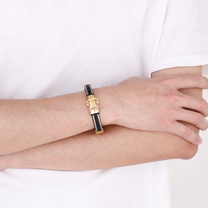 Dettaglio del bracciale in pelle intrecciata nera da uomo con chiusura ad ancora dorata