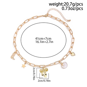 Detailed view of golden necklace with bow, shell and star charms including size markings