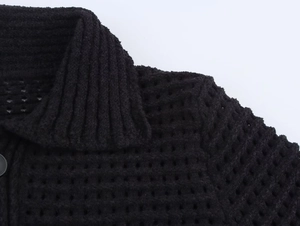 Dettaglio maglione nero in maglia con trama a nido d'ape e colletto a risvolto
