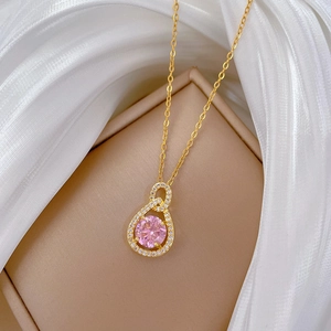 Elegant gold-plated teardrop necklace with pink center stone on beige gift box