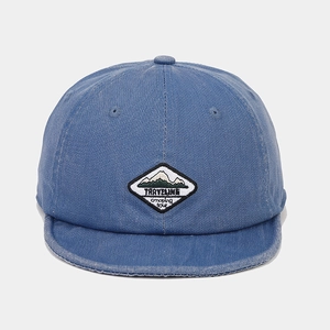 Close-up of a navy cotton short brim cap featuring a mountain embroidered patch