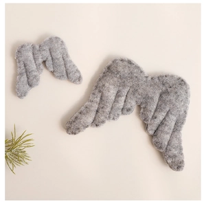 Detail of grey felt angel wings in two sizes for Nordic Christmas decor on beige background