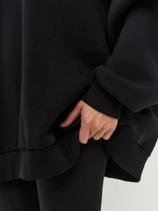 Detailed macro of black cotton sweatshirt featuring ribbed cuffs and thick fleece texture