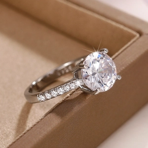 Macro shot of silver ring featuring a four-prong round zircon and pavé diamond band