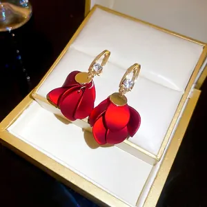 Elegant red matte petal earrings with gold hooks and rhinestones in jewelry box