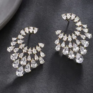 Detail of gold-tone wing earrings featuring layered pear-cut sparkling zircon stones