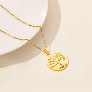 Detailed close-up of golden stainless steel necklace with round tree of life pendant