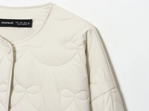 Detail shot of heart quilted jacket collar with buttons and internal brand size label