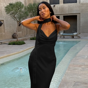 Macro detail of elegant black satin long dress with sophisticated halter scarf neckline
