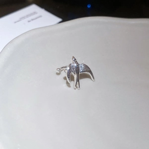 Macro shot of silver bird open ring featuring sparkling pavé zircon wings on tray