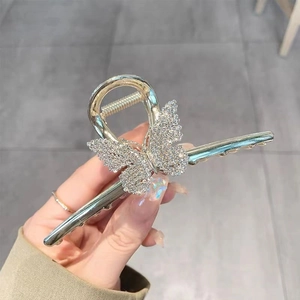 Macro detail of silver metal butterfly hair claw clip with sparkling rhinestones decoration
