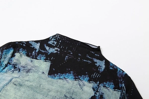 Detailed view of the mock neck and shoulder on an abstract print long-sleeve top