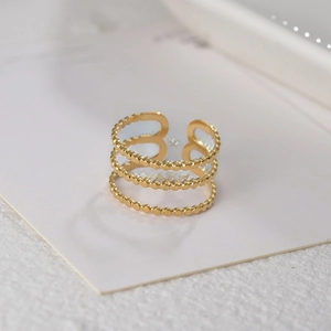 Detailed macro view of triple-layered gold beaded open ring with adjustable band