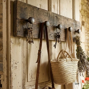 Vintage iron wall hooks on dark solid wood base mounted on ivory white door