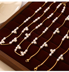 Detail of freshwater pearl jewelry set with gold accents on velvet display tray