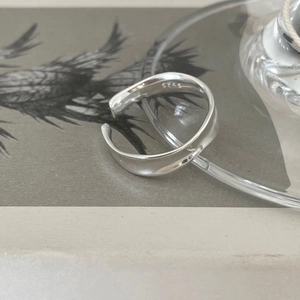 Detail shot of irregular S925 sterling silver ring showing smooth wave-like surface and engraving