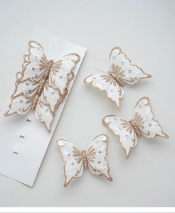 Detailansicht eleganter weißer Stoffschmetterlinge mit goldenem Glitzer und Pailletten