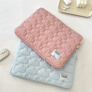 Detail of cloud quilted laptop sleeve fabric with embroidered label and soft padding