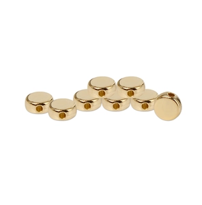 Macro view of gold flat round CCB spacer beads with metallic luster for jewelry making