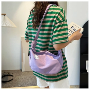 Detailed side view of lavender crescent crossbody bag featuring adjustable strap and puppy charm