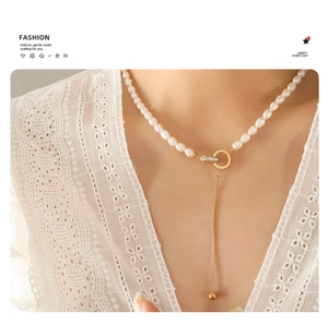 Detail of baroque freshwater pearl pendant necklace with Roman numerals and golden fringe