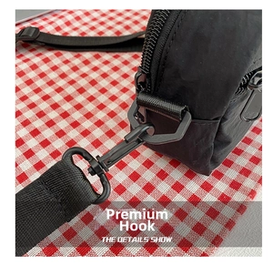 Detail showing black nylon shoulder bag with premium plastic hook and strap attachment