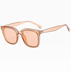 Detail view of transparent orange oversized sunglasses with retro frame and tinted lenses