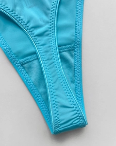 Macro shot of turquoise high-elastic ice silk thong fabric with reinforced zigzag stitching
