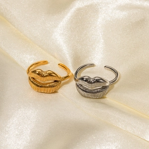 Bagues en forme de lèvres en acier inoxydable or 18 carats et argent sur satin beige