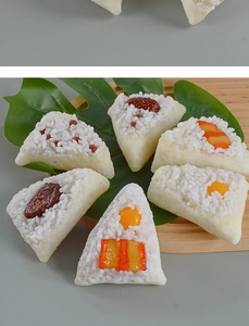 Detailed view of assorted PVC artificial rice dumplings with fillings on a wooden tray