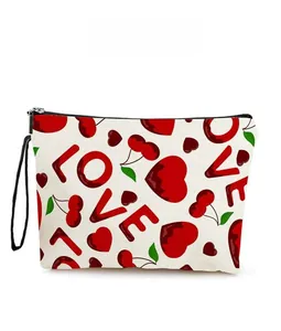 Close-up of heart and cherry patterns on canvas makeup bag with black zipper detail