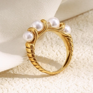 Macro shot of 18K gold plated spiral ring with five pearls on a white background